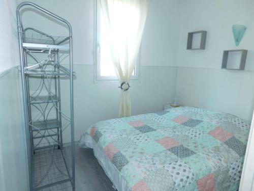 um quarto com uma cama e uma escada ao lado de uma janela em Le petit nid em Lourdes