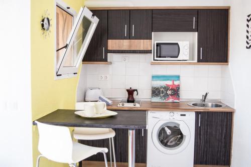 małą kuchnię z pralką i zlewem w obiekcie MerieElisabethSunApartment w Corralejo