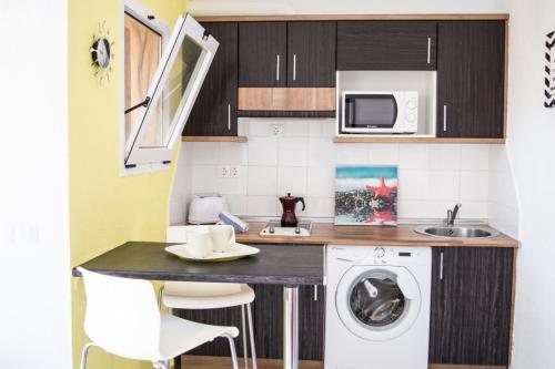 a small kitchen with a washing machine and a sink at MerieElisabethSunApartment in Corralejo