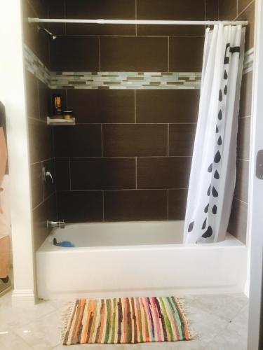 a bathroom with a bath tub with a shower curtain at Hollywood Stay in Los Angeles
