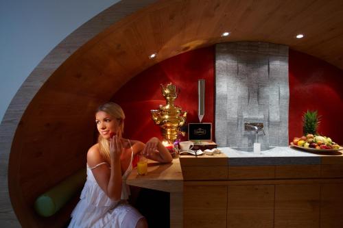a woman is sitting in a bath tub in a bathroom at Hotel Tirol in Ischgl