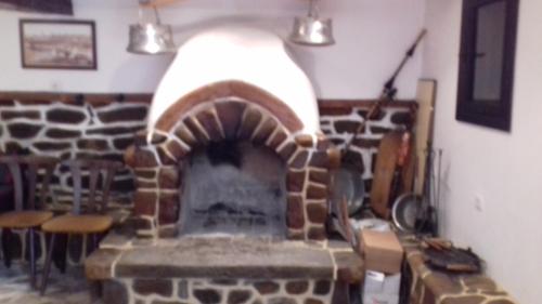 a brick fireplace in a room with two lights at Горска къща в Елена Петроф хоф in Elena