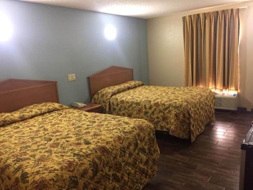 ein Hotelzimmer mit 2 Betten und einem Fenster in der Unterkunft Briarwood Inn in Pine Bluff