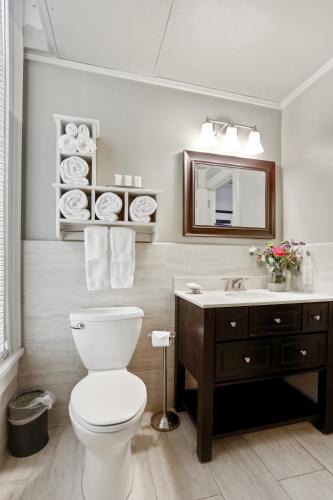 a bathroom with a toilet and a sink and a mirror at La Galerie French Quarter Hotel in New Orleans