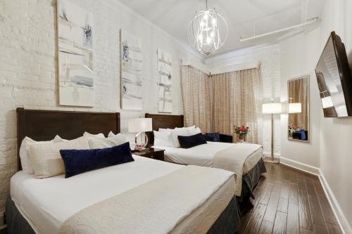 a hotel room with two beds and a chandelier at La Galerie French Quarter Hotel in New Orleans