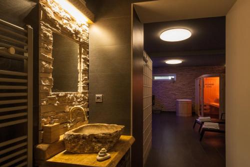 La salle de bains est pourvue d'un lavabo et d'un mur en pierre. dans l'établissement Penzion Agáta, à Žehrov
