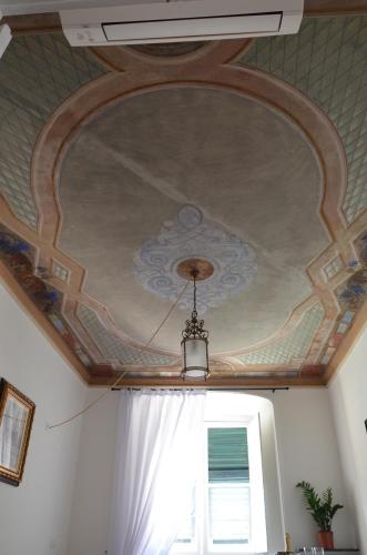 a coffered ceiling in a room with a window at Le coccole in Genova