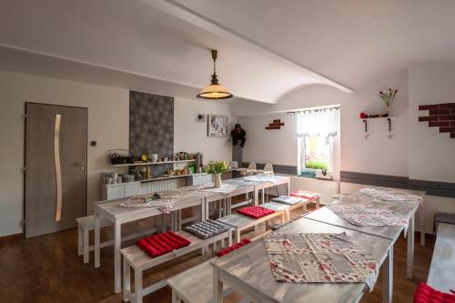 a room with tables and chairs and a kitchen at Penzion Agáta in Žehrov