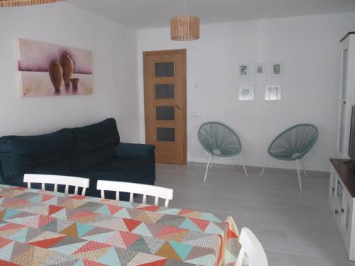 ein Wohnzimmer mit einem Sofa und 2 Stühlen in der Unterkunft Apartamento recién reformado y climatizado en ubicación inmejorable. in Peñíscola