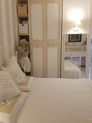 a bedroom with a white bed and a mirror at La Cameretta in Ischia