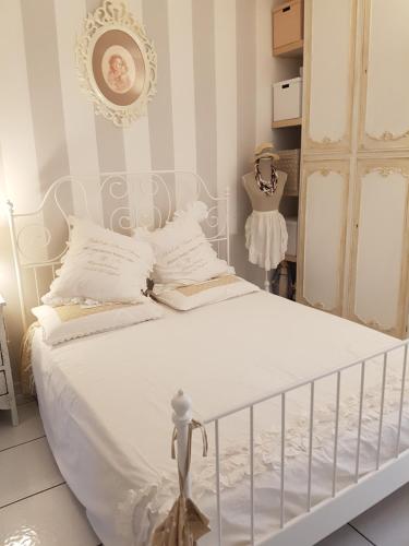 a bedroom with a white bed with white sheets and a dummy at La Cameretta in Ischia