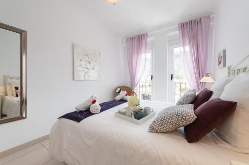 1 dormitorio con 1 cama grande con almohadas y ventana en Mogan Beach | CarmitAtHome, en Puerto de Mogán