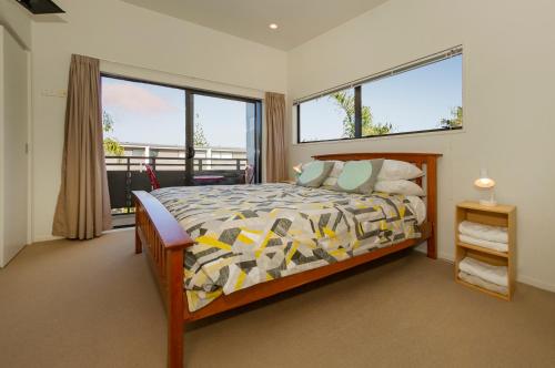 a bedroom with a bed and a large window at Aqua Soleil Villas in Whitianga