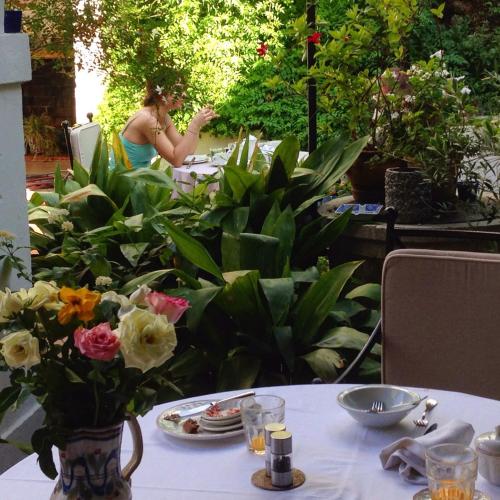 a woman sitting at a table with a vase of flowers at Sant Jaume in Alcudia