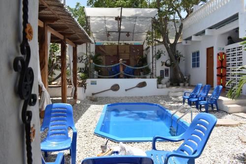 a patio with blue chairs and a swimming pool at Hostal Palohe Taganga in Taganga