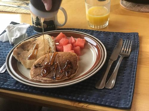 a plate of food with a sandwich and fruit on a table at Devils Tower Lodge in Devils Tower
