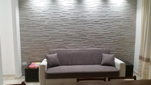 a couch sitting in front of a brick wall at La casa di Laura in Tortolì