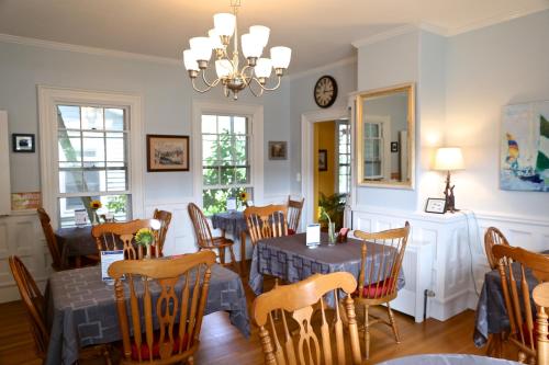 a dining room with tables and chairs and a chandelier at Camden Windward House in Camden