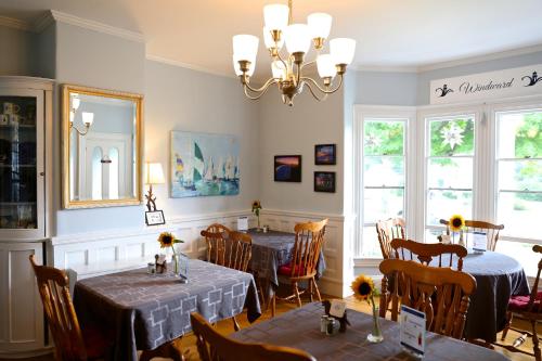 a dining room with tables and chairs and a chandelier at Camden Windward House in Camden