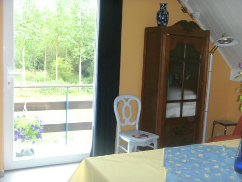 Ferme Lenfant في Ville-Pommeroeul: غرفة نوم بسرير وكرسي ونافذة