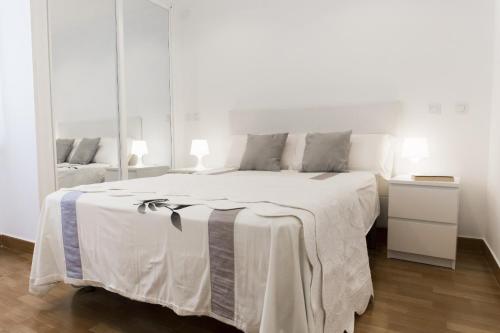 マラガにあるWonderful Holidaysの白いベッドルーム(大きな白いベッド1台、テーブル付)