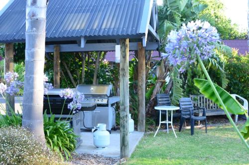 a grill in a garden with a table and chairs at Tropicana Motor Inn in Cowes
