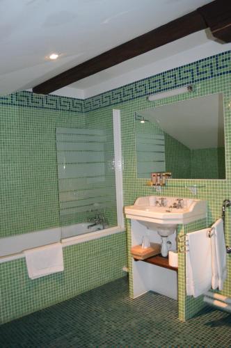 une salle de bain avec un lavabo, une baignoire et un miroir dans l'établissement La Ferme Ostalapia, à Ahetze