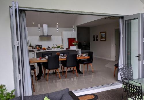 a kitchen and dining room with a table and chairs at Karapiro Willows Luxury B & B in Cambridge