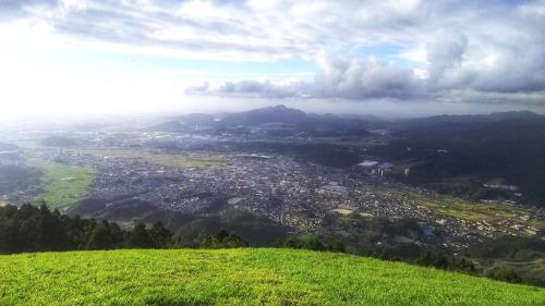 a view of a city from a green hill at Joy House in Imari