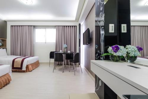 a hotel room with a bed and a table at Harmonious Hotel in Kaohsiung
