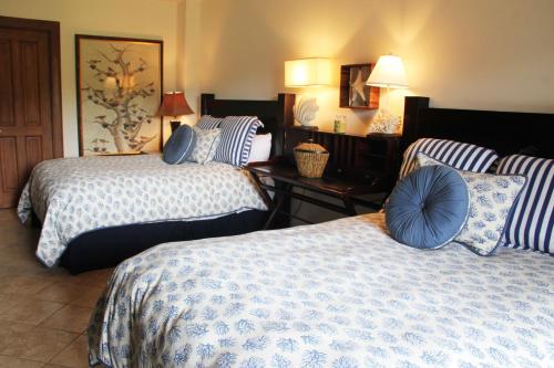 Habitación de hotel con 2 camas y almohadas azules en Los Suenos Resort Veranda 2B by Stay in CR, en Herradura