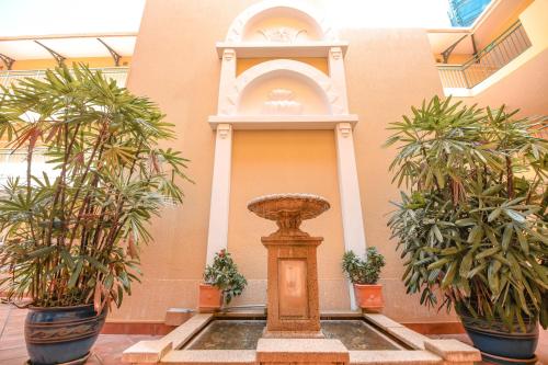 a fountain in a building with two potted plants at Il Palazzo Holiday Apartments in Cairns