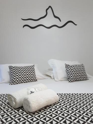 a bedroom with a white bed with black and white pillows at Pousada Morro do Pico in Fernando de Noronha