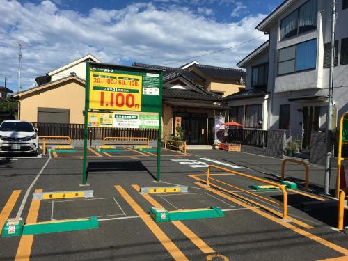 a parking lot with a sign in front of a building at Ryokan Niko in Koganei
