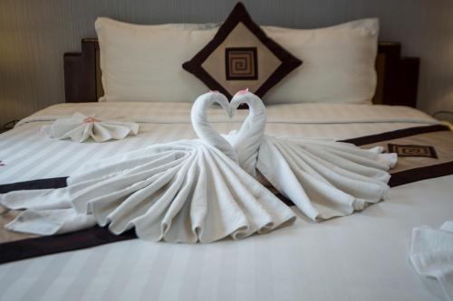 two white swansrendered to look like they are kissing on a bed at Splendid Star Grand Hotel and Spa in Hanoi