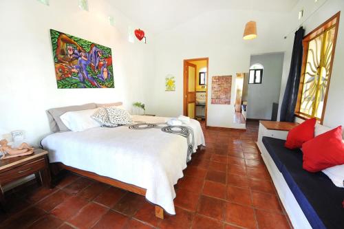a bedroom with a bed and a couch in it at Hotel Villa Mozart y Macondo in Puerto Escondido