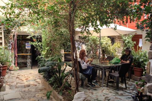 two people sitting at a table under an umbrella at Eureka Lodge in Ollantaytambo