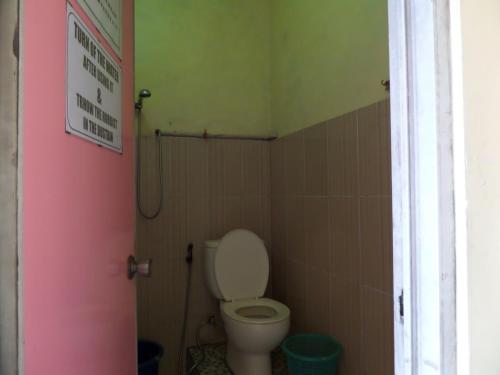 a bathroom with a toilet and a pink door at Tengger Indah Homestay in Bromo