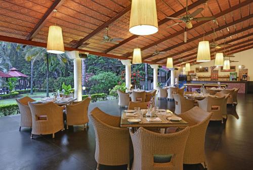 a restaurant with tables and chairs and a bar at Royal Orchid Resort & Convention Centre, Yelahanka Bangalore in Bangalore