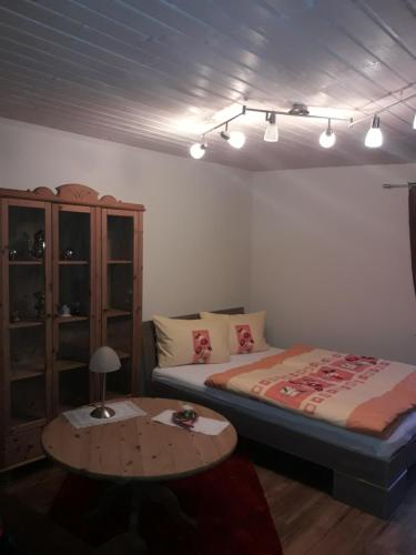 Schlafzimmer mit einem Bett, einem Tisch und Lampen in der Unterkunft Gemütliche Zimmer in Kaisersesch