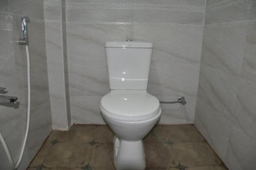 a bathroom with a white toilet in a stall at Moonlight Residency in Tiruchchirāppalli
