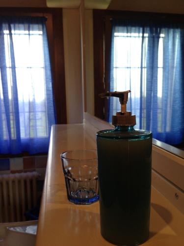 a bottle of soap on a counter next to a glass at El Pendola in Fumane