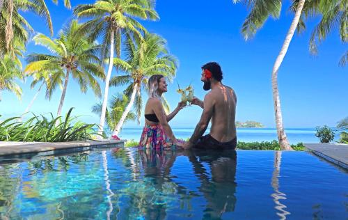 un hombre y una mujer sentados en una piscina en Tropica Island Resort-Adults Only en Malolo