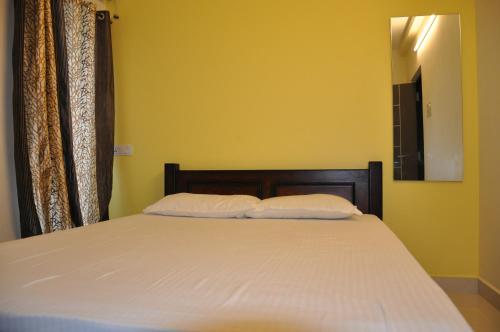 a bedroom with a bed with two pillows on it at Moonlight Residency in Tiruchchirāppalli