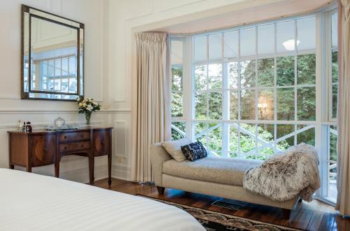a bedroom with a couch and a large window at Moulton Park Estate - Homestead in Sassafras