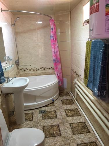 a bathroom with a tub and a toilet and a sink at Shahram Plus Boutique Hotel Registan B&B in Samarkand