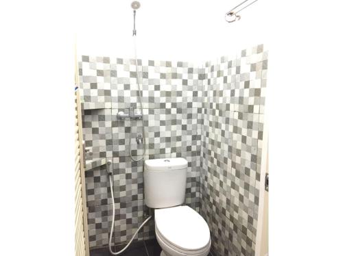 a bathroom with a toilet and a shower with checkered tiles at Rumah Baraka in Yogyakarta