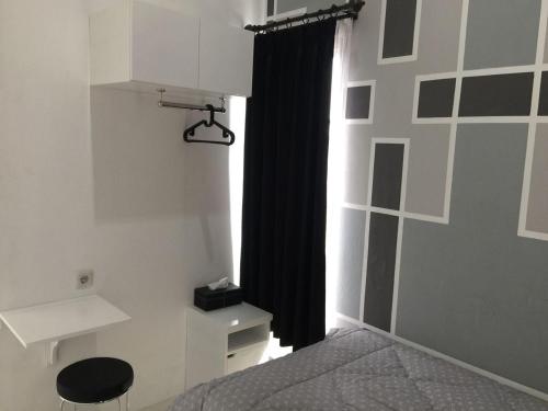 a bedroom with a bed and a black curtain at Rumah Baraka in Yogyakarta