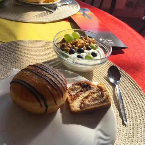 un piatto di cibo con una ciambella e una ciotola di pane di Hotelový resort Šikland a Zvole