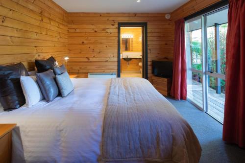 a bedroom with a large bed and a television at Westwood Lodge in Franz Josef